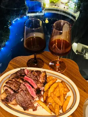 a plate of steak and french fries and two glasses of wine at CASA VANA in AZURE STAYCATION in Manila