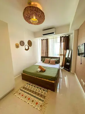 a bedroom with a green bed and a rug at CASA VANA in AZURE STAYCATION in Manila
