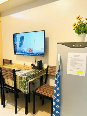 a room with a table with a television on a wall at Sea Residences Elegant Place by Bella in Manila