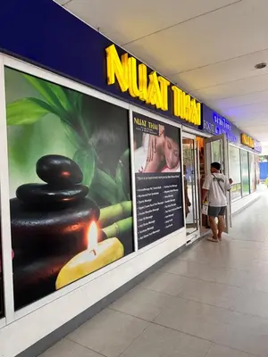 a woman walking down a hallway in a mall with posters at Sea Residences Elegant Place by Bella in Manila