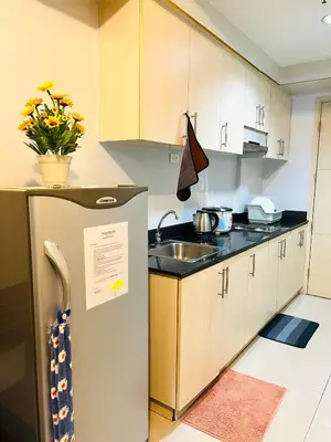 a kitchen with a sink and a refrigerator at Sea Residences Elegant Place by Bella in Manila