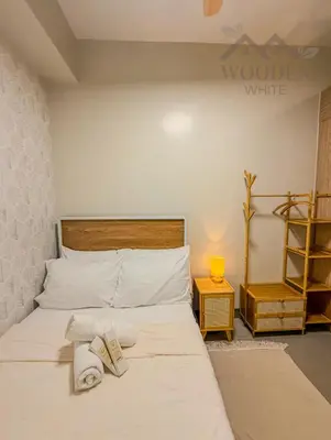 a bedroom with a bed with two towels on it at Wooden White in Manila