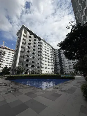 a large apartment building with a pond in front of it at Wooden White in Manila