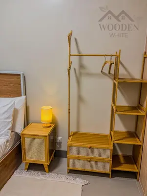 a bedroom with a bed and a yellow shelf and a table at Wooden White in Manila