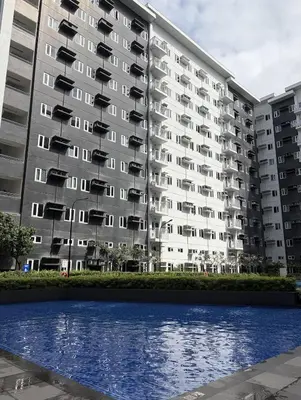 an apartment building with a pool in front of it at Wooden White in Manila