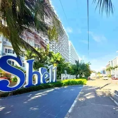 a sign in front of a building with a palm tree at The Executive Suites by PJTai Realty Shell002 - 1BR in Manila