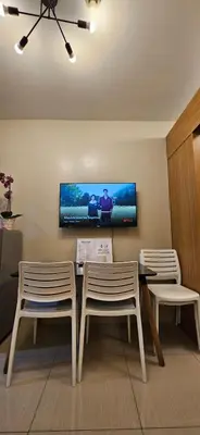 a living room with a table and two chairs and a tv at The Executive Suites by PJTai Realty Shell002 - 1BR in Manila