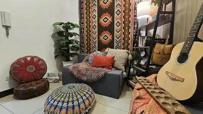 a living room with a couch and a guitar at PROMO Modern Boho Chic Condo Near MOA, Manila Bay in Manila