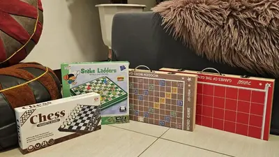 a table topped with boxes of chess and a calendar at PROMO Modern Boho Chic Condo Near MOA, Manila Bay in Manila