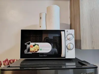 a microwave sitting on top of a stove at PROMO Modern Boho Chic Condo Near MOA, Manila Bay in Manila