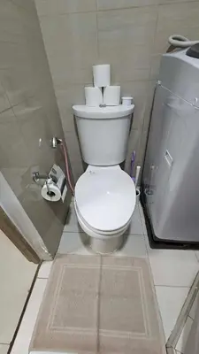 a bathroom with a toilet and a glass wall at PROMO Modern Boho Chic Condo Near MOA, Manila Bay in Manila