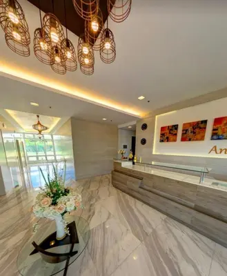 a lobby with a waiting area with flowers on a table at The Global Nest at Anuva Modern 1BR with Pool in Manila