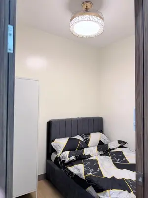 a bedroom with a bed and a light at 2 BR Modern Apartment Near the Airport in Manila