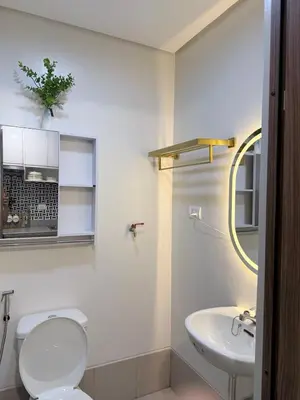 a white bathroom with a toilet and a sink at 2 BR Modern Apartment Near the Airport in Manila