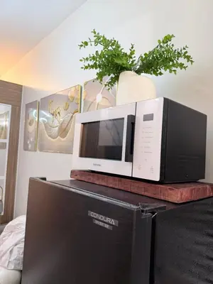 a microwave sitting on top of a tv at 2 BR Modern Apartment Near the Airport in Manila