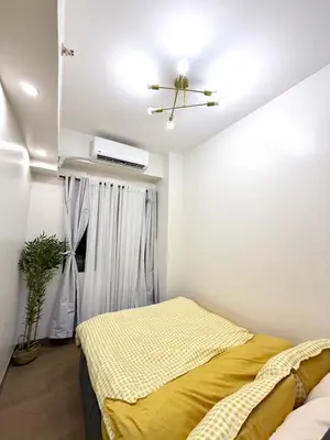 a bedroom with a bed and a ceiling fan at 2 BR Modern Apartment Near the Airport in Manila
