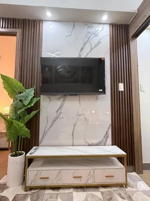 a living room with a tv on a wall at 2 BR Modern Apartment Near the Airport in Manila