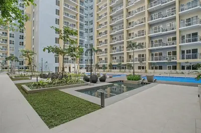 a large apartment building with a courtyard with a swimming pool at Sunset Retreat - 4 Bedroom Home near Solaire 14pax in Manila