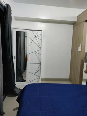 a bedroom with a blue bed and a mirror at Shore 2 Residences Tower 1 JayDa in Manila