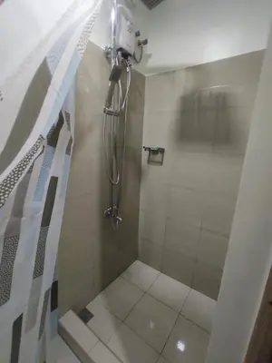 a bathroom with a shower with a glass door at Shore 2 Residences Tower 1 JayDa in Manila