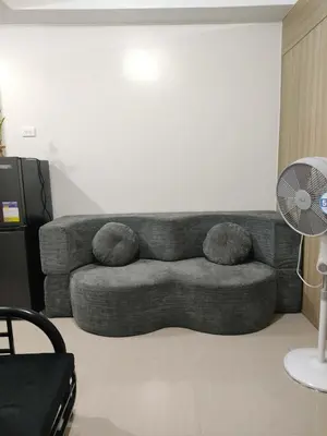 a living room with a couch and a fan at Shore 2 Residences Tower 1 JayDa in Manila