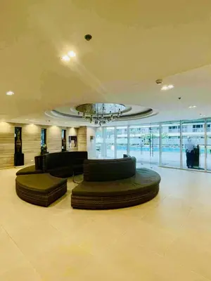 a large lobby with two bean bags and a chandelier at JL's City Hideaway at Fame Residences in Manila