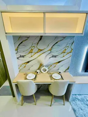 a dining room table with two chairs and a mural at JL's City Hideaway at Fame Residences in Manila