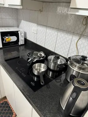 a kitchen counter with pots and pans on a stove at Next Abode 1BR at TheBeaconMakati in Manila
