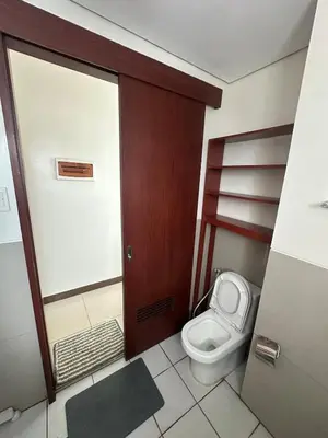 a bathroom with a toilet and a door at Next Abode Modern Stay at TheBeaconMakatiRoces in Manila