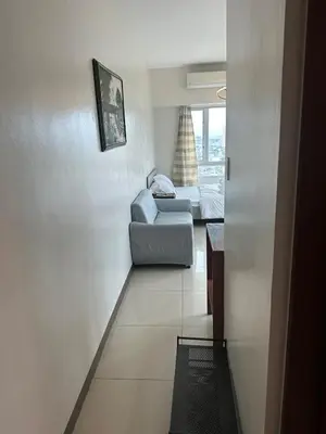 a living room with a chair and a couch at Next Abode Modern Stay at TheBeaconMakatiRoces in Manila