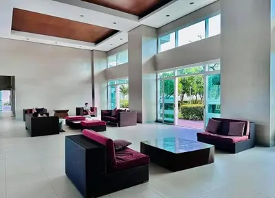 a large lobby with couches and tables and windows at Next Abode Modern Stay at TheBeaconMakatiRoces in Manila