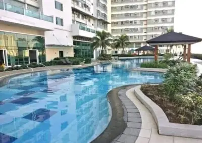 a large swimming pool in front of a building at Next Abode Modern Stay at TheBeaconMakatiRoces in Manila