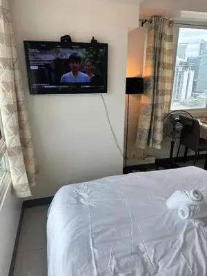 a hotel room with a tv on the wall at Next Abode Modern Stay at TheBeaconMakatiRoces in Manila