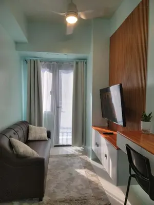 a living room with a couch and a flat screen tv at The Nook at the Shore in Manila