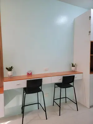 a kitchen with two chairs and a counter with a desk at The Nook at the Shore in Manila