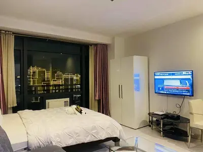 a bedroom with a white bed and a television at The Gramercy Residences in Manila