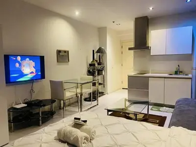 a living room with a couch and a table and a kitchen at The Gramercy Residences in Manila