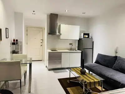 a kitchen and living room with a couch and a table at The Gramercy Residences in Manila
