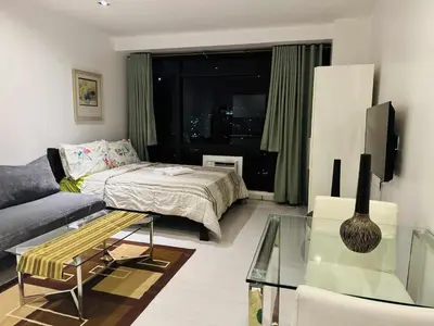 a living room with a bed and a couch at The Gramercy Residences in Manila
