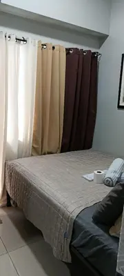 a bed in a room with curtains in a bedroom at DIRECT TO POOL Shore Residences by heart in Manila