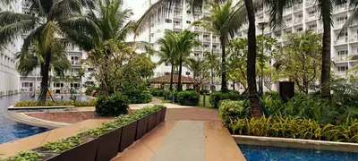 a resort with a pool and palm trees and a building at DIRECT TO POOL Shore Residences by heart in Manila