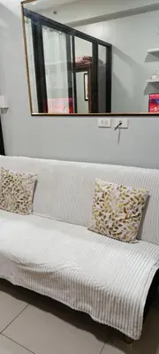 a white couch in a room with a mirror at DIRECT TO POOL Shore Residences by heart in Manila