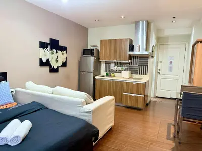 a room with a kitchen with a bed and a refrigerator at The Gramercy Residences in Manila