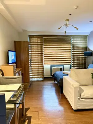 a living room with a couch and a tv at The Gramercy Residences in Manila