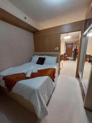 a bedroom with a large bed with white sheets at Condotel SM MOA sea residences in Manila
