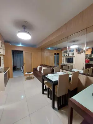a kitchen and living room with a table and a couch at Condotel SM MOA sea residences in Manila