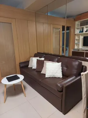 a brown leather couch in a living room with a table at Condotel SM MOA sea residences in Manila