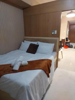 a bedroom with a large bed with white sheets at Condotel SM MOA sea residences in Manila