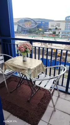 a table with a vase of flowers on a balcony at She'll residences condotel in Manila