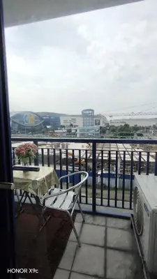 a balcony with a table and a view of the water at She'll residences condotel in Manila